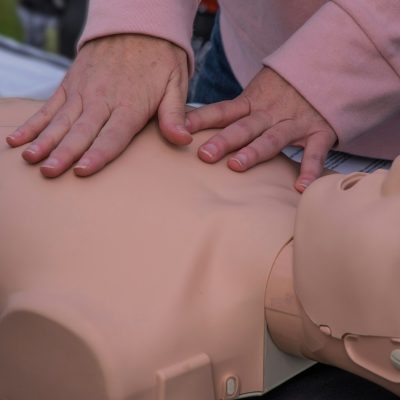 Medical technician demonstrates CPR on a dummy at a job fair